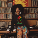 Woman in a record store wearing a sweatshirt with a colorful design and text.